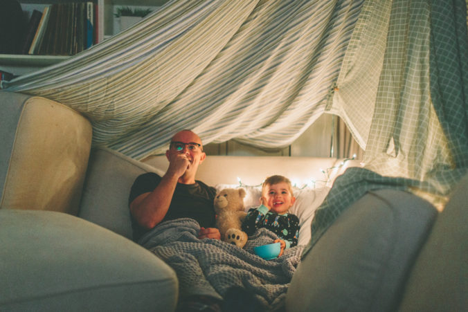 Papa und Kind schauen Fernsehen unter Deckenhöhle